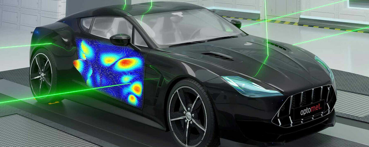 A car in a test lab with laser beams directed at it for vibration measurement. A colorful vibration pattern is displayed on the driver’s door.