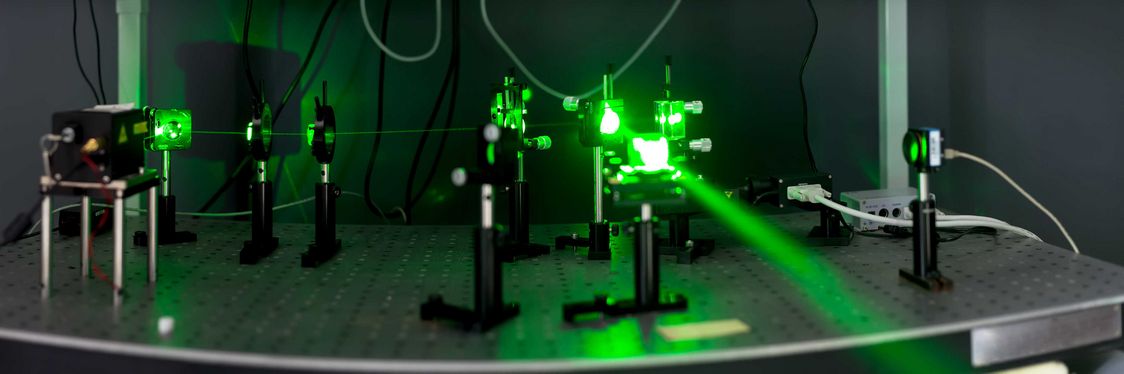 Ein Laser Vibrometer im Einsatz, welcher eingeschaltet einen Grünen Laser erzeugt und auf einen Spiegel ausgerichtet ist, welcher diesen auf andere Objekte reflektiert. 