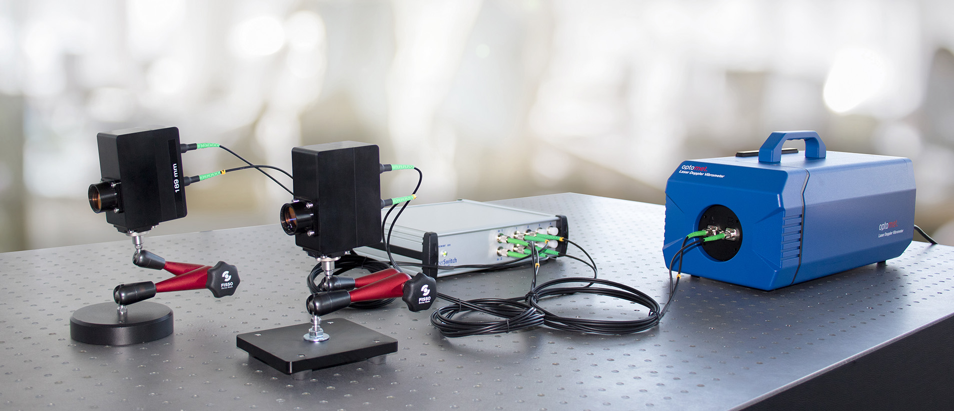Configuración de medición con un vibrómetro láser de fibra, varios cabezales de medición y accesorios.